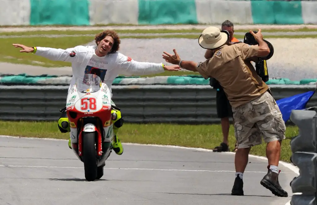 Italian rider Marco Simoncelli of Gilera celebrates at the end of 250 cc Malaysian Grand Prix on October 19, 2008, in Sepang.  Simoncelli on a Gilera won the 250cc series world championship for the first time after coming third in the Malaysian Grand Prix. AFP PHOTO / Saeed KHAN (Photo credit should read SAEED KHAN/AFP via Getty Images)